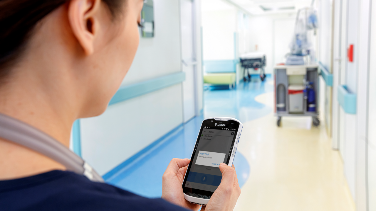 A nurse checks an alert on her clinical smartphone
